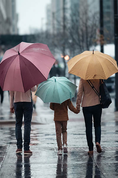 Figures together beneath umbrellas — not alone in the storm