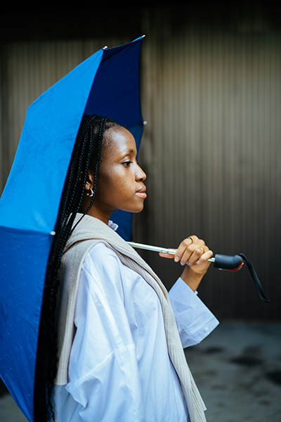 A person standing calm beneath an open umbrella